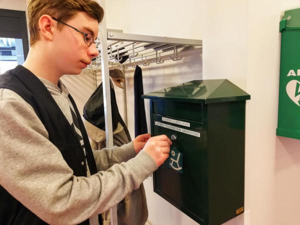 poika laittaa kirjeen postilaatikkoon
