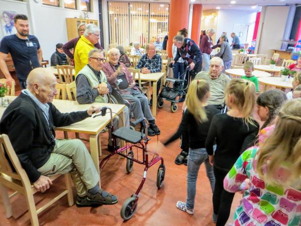 Lapset leikkivät vanhusten edessä