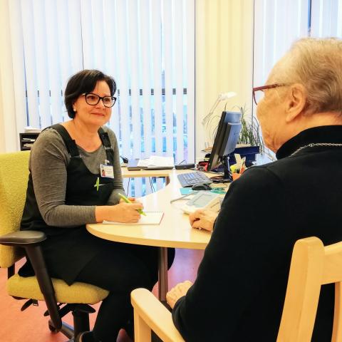 Sairaanhoitaja keskustelee ikäihmisen kanssa
